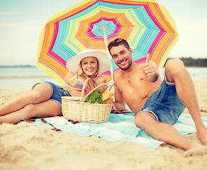 Image showing smiling couple sunbathing on the beach