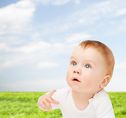 Image showing curious baby lying on floor and looking up