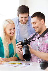 Image showing smiling team with photocamera working in office