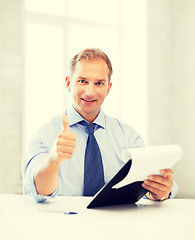 Image showing businessman with papers showing thumbs up