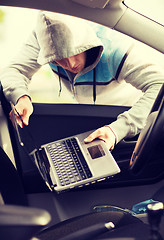 Image showing thief stealing laptop from the car