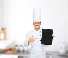 Image showing smiling female chef with black blank paper