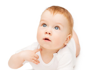 Image showing curious baby lying on floor and looking up