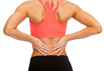 Image showing close up of sporty woman touching her back