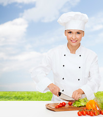 Image showing smiling female chef chopping vegetables