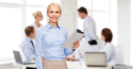 Image showing smiling woman looking at tablet pc computer