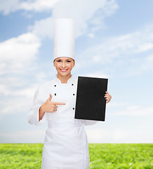 Image showing smiling female chef with black blank paper