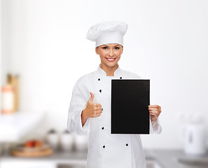 Image showing smiling female chef with black blank paper