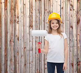 Image showing smiling little girl in helmet with paint roller