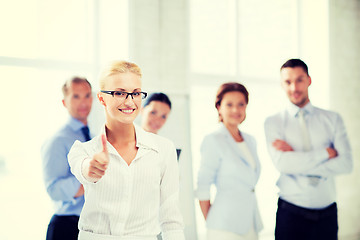 Image showing businesswoman in office showign thumbs up