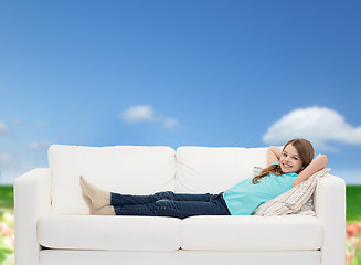 Image showing smiling little girl lying on sofa