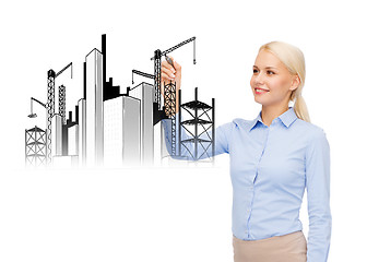 Image showing smiling businesswoman drawing construction site