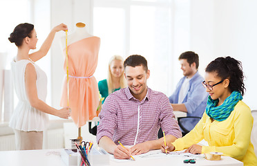 Image showing smiling fashion designers working in office