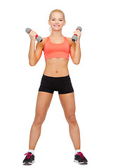 Image showing smiling beautiful sporty woman with dumbbells