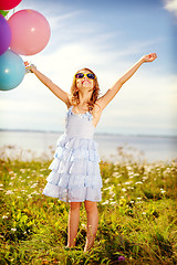 Image showing happy girl waving hands with colorful balloons