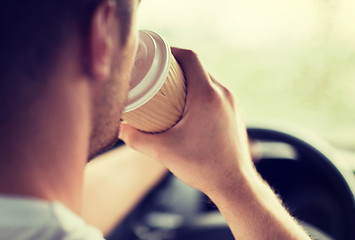 Image showing man drinking coffee while driving the car