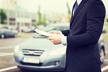 Image showing man with car documents outside