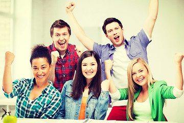 Image showing students holding hands up at school