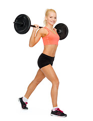 Image showing smiling sporty woman exercising with barbell