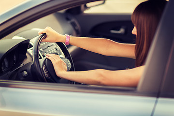 Image showing woman driving a car with hand on horn button