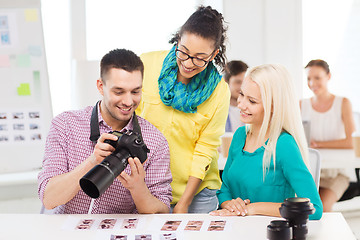 Image showing smiling team with photocamera working in office