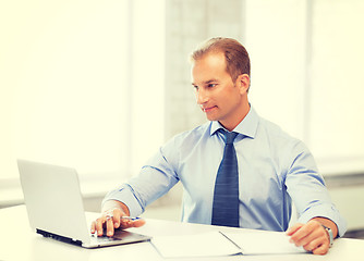 Image showing miling businessman working in office