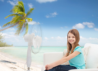 Image showing smiling little girl with big fan at home