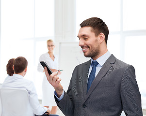 Image showing young smiling businessman with smartphone