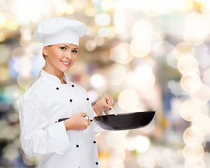 Image showing smiling female chef with pan and spoon