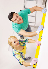 Image showing couple building using spirit level to measure