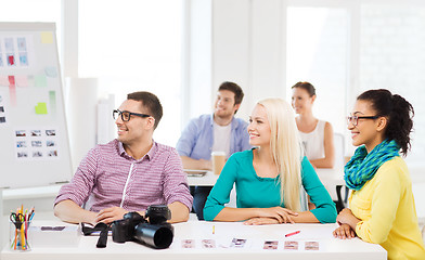 Image showing smiling team with photocamera working in office