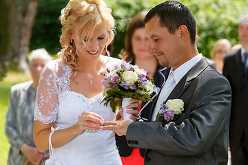 Image showing beautiful young wedding couple exchange wedding rings