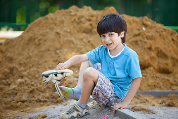 Image showing boy pours the sand out of the shoe