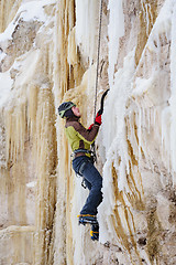 Image showing Young man climbing the ice