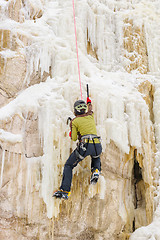 Image showing Young man climbing the ice