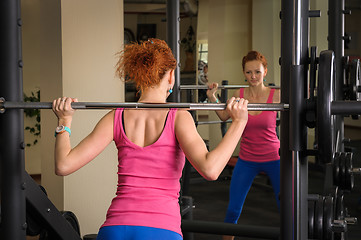 Image showing young girl doing squats with barbell