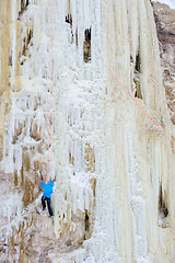 Image showing Young man climbing the ice