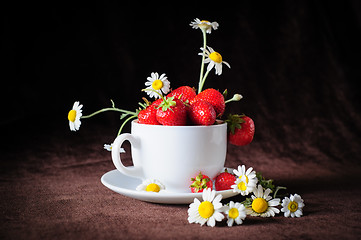 Image showing chamomiles and strawberries in the cup