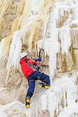 Image showing Young man climbing the ice