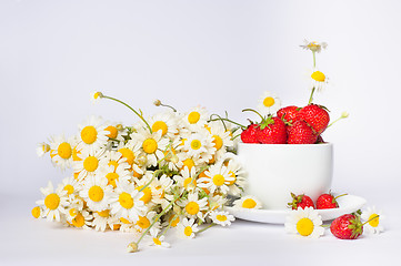 Image showing chamomiles and strawberries in the cup