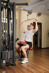 Image showing Young man doing lats pull-down workout in gym