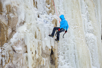 Image showing Young man climbing the ice