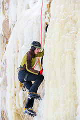 Image showing Young man climbing the ice