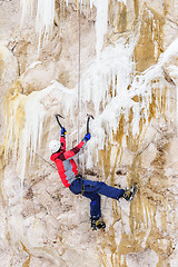 Image showing Young man climbing the ice