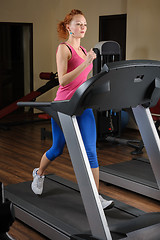 Image showing young man running at treadmill in gym