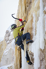 Image showing Young man climbing the ice