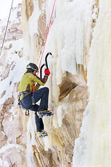 Image showing Young man climbing the ice