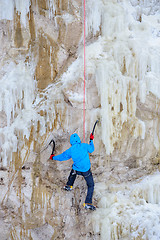 Image showing Young man climbing the ice