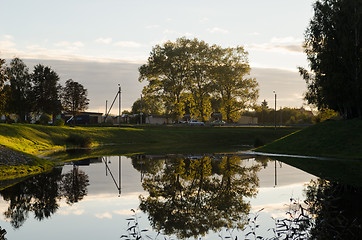 Image showing trees reflected in clear water natural moment  