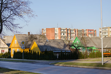 Image showing rural wooden house and multistorey red brick house 